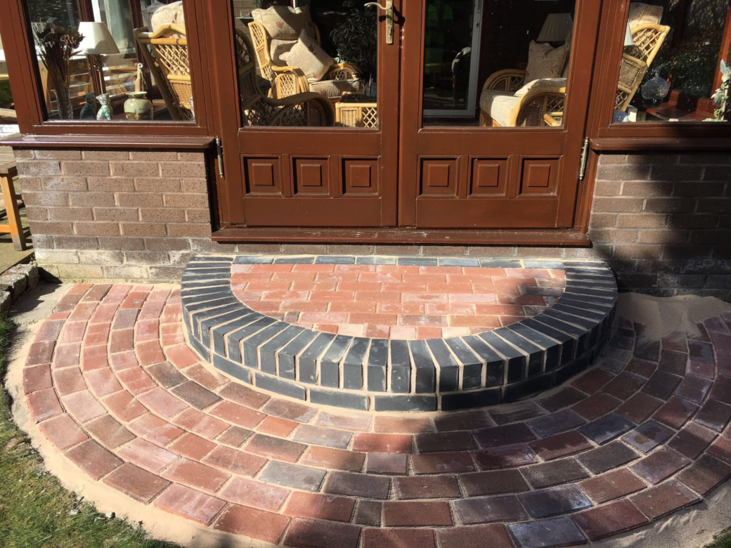 Curved brick step and radial block apron to conservatory doors